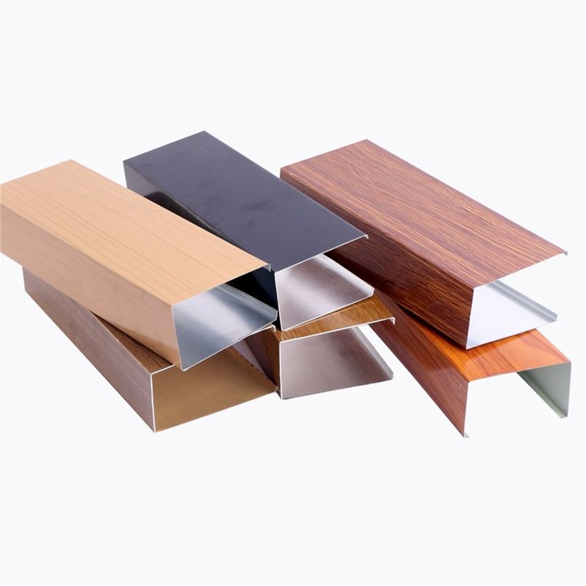 Aluminum U-shaped baffle profile samples in woodgrain and dark finishes on a light background