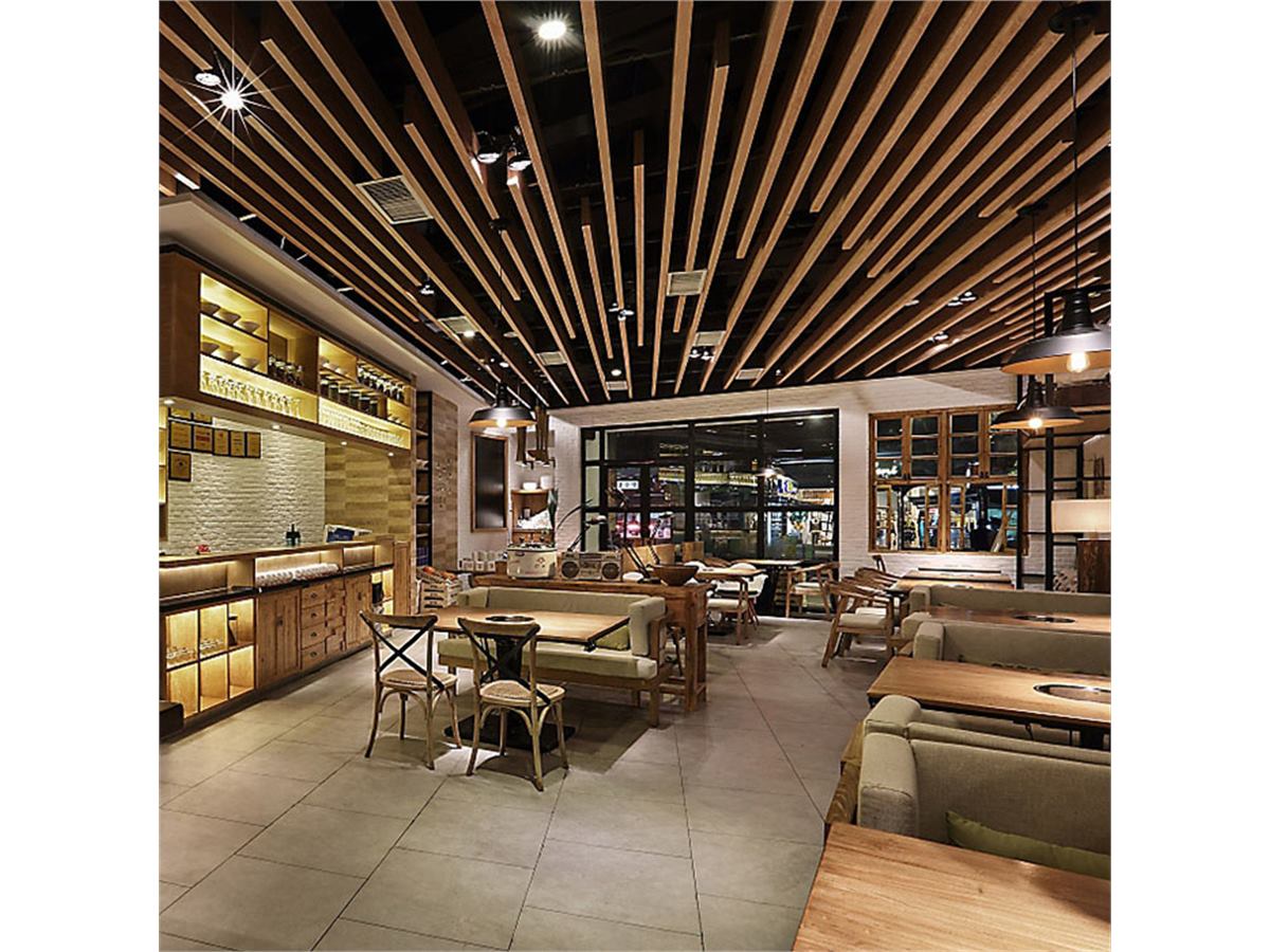 Brown linear aluminum baffle ceiling with integrated lighting above restaurant seating
