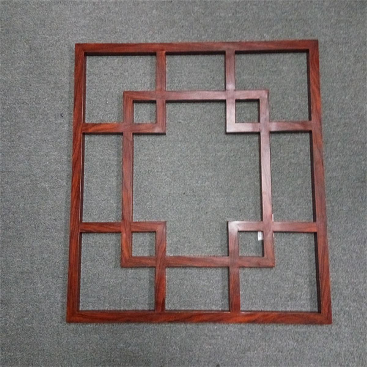 Wood-toned geometric grille frame displayed against a neutral background